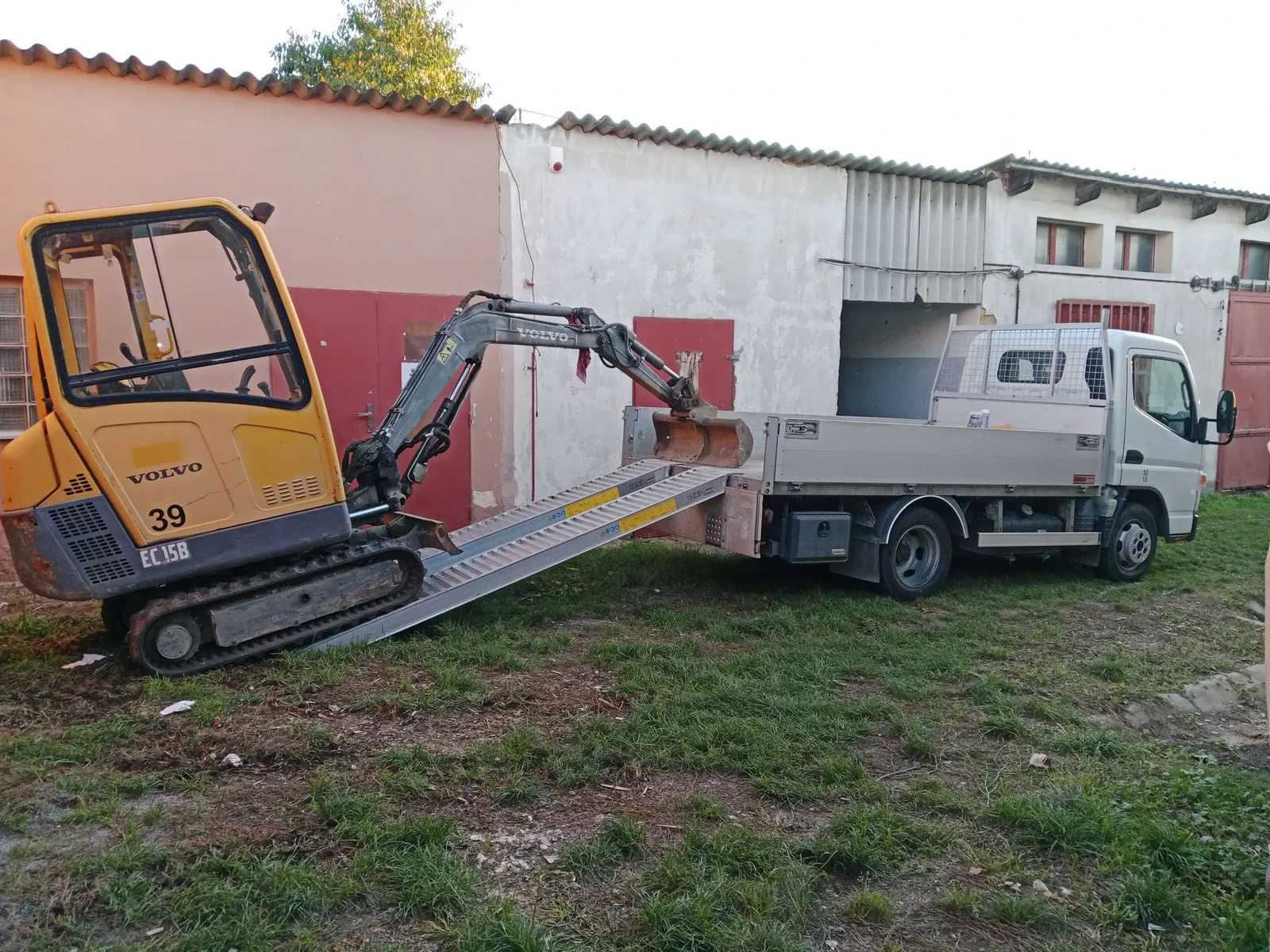 Minibagr Volvo sjíždí z valníku
